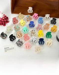 Vue détaillée de mini pinces à cheveux en acétate colorées aux motifs variés