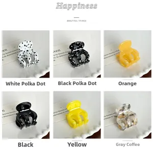 Mini pinces à cheveux en acétate coloré présentées sur une assiette en céramique décorative