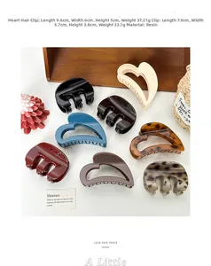Close-up of assorted resin hair claws with heart cutouts and classic marbled designs