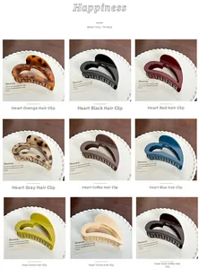 Nine colors of heart-shaped hair claw clips displayed on a stylish wooden background
