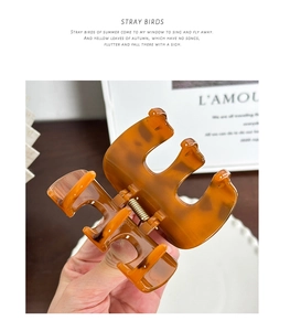 Detail of amber tortoiseshell hair claw clip with glossy finish and spring mechanism