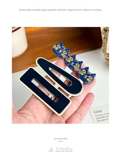 Detailed macro view of acetate hair clip set showing premium texture and golden cat motif