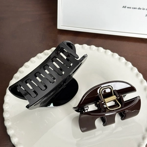 Minimalist glossy hair claw clips in black rectangle and brown semi-circle styles