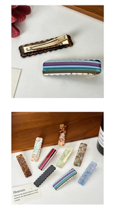 Détail des barrettes à cheveux ondulées en acétate avec motifs marbrés et pince en métal