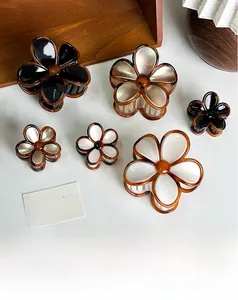 Detailed view of plumeria flower hair claws in various sizes and pearlized colors