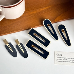 Five-piece set of navy and cream acetate hair clips with golden metal duckbill grips