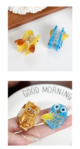 Detail of mini owl hair clips showing marble texture acetate and small metal spring