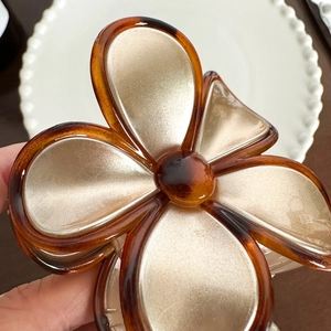 Elegant floral hair claw with amber edges and champagne gold petals for a retro look