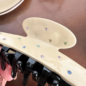 Elegant contrast acetate hair claw clip with colorful rhinestones on a cream finish