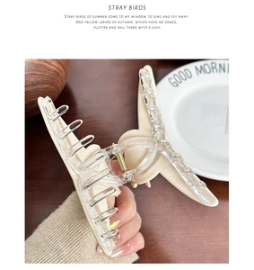 Detail of beige bear hair claw clip with transparent teeth and strong gold metal spring