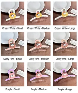 Detailansicht bunter Acryl-Haarklammern mit süßem Monstergesicht und Lucky-Aufdruck