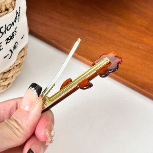 Floral acetate hair clip in tortoiseshell finish with elegant gold metal duckbill clip