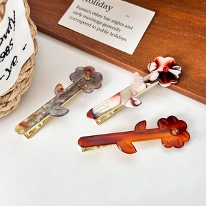 Three-piece acetate floral hair clips set in amber, marble, and bicolor patterns