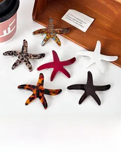Detail of six colorful starfish acetate hair clips with various marble patterns