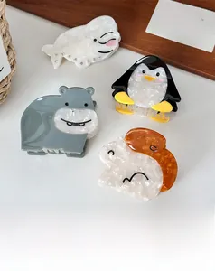 Detail of cute animal acetate hair claws featuring penguin, hippo and whale shapes