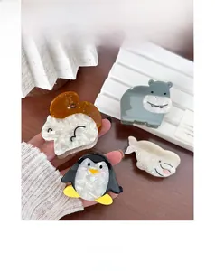 Detailed view of acetate animal hair claws showing marble texture and penguin shape