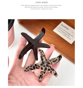 Detailed macro view of two starfish acetate hair clips in brown and leopard pattern