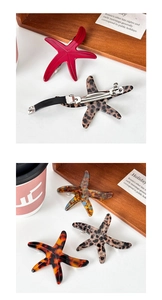 Detail of starfish acetate hair clip showing the metal spring clamp and resin textures