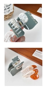 Detail of cute acetate cat-shaped hair claws in green, amber, and marble white finishes