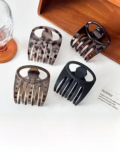 Detailed view of four geometric hair claws in leopard, tortoiseshell, and matte finishes