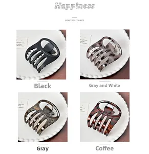 Detail of four large hair claw clips in black, leopard, transparent grey, and tortoise shell