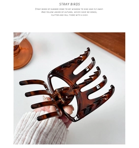 Detail view of large dark brown tortoiseshell hair claw clip with strong metal spring grip