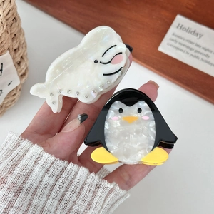 Cute acetate hair claws featuring cartoon penguin and seal designs with sparkling rhinestones