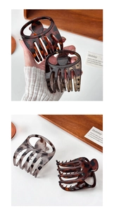Detail showing tortoise shell and leopard pattern hair clips on a wooden tray