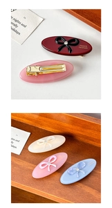 Detailed macro view of acetate hair clips featuring sparkly bow knots and gold engraving