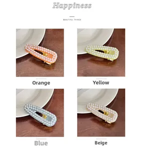 Detailed close-up of hollow teardrop hair clips with rows of inlaid pearls in four colors