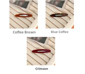 Trois barrettes en acétate café, bleu et rouge cinabre sur un plateau à bijoux fini