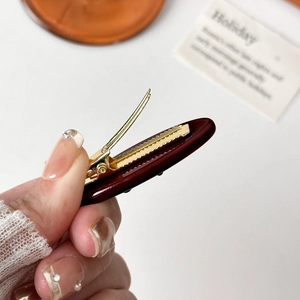 Sparkling diamond bow acetate hair clip in deep burgundy with gold metal clip