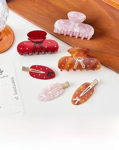 Detail view of acetate hair claws and clips with bow relief and small rhinestones