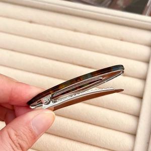 Pince à cheveux motif écaille de tortue avec une base en métal argenté poli brillant