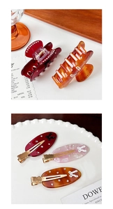 Detailed macro view of acetate hair clips with crystal accents and white bow patterns