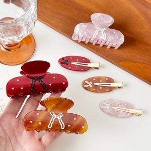 Bow design acetic hair claw set with rhinestones in red, marble pink, and amber finishes