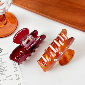 Elegant bow-shaped acetate hair claw clips with rhinestones in burgundy and amber