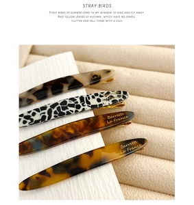 Detailed macro view of four French style acetate hair clips in tortoiseshell and cow prints