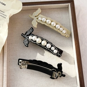 Eleganti mollette per capelli in acetato di cellulosa con perle e strass su vassoio legno