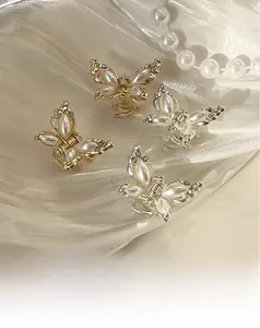 Detailansicht von Schmetterlings-Haarklammern mit Perlen und Strass auf Satin