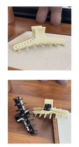 Detail of large acetate hair claw clip with elegant pearls on wooden background