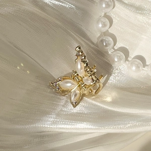 Eleganter goldener Schmetterlings-Haarclip mit Perlen und Strass auf weißem Seidenstoff