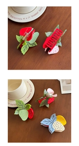 Détail de pinces à cheveux fraise colorées en acétate avec finition lisse et ressort métal