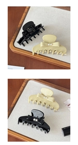 Détail de pinces à cheveux élégantes noires et crème avec nœuds en perles et fini brillant