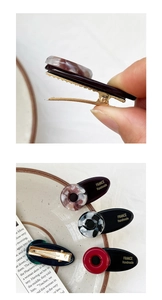 Nahaufnahme handgefertigter Haarspangen aus Harz mit France Handmade Goldaufdruck