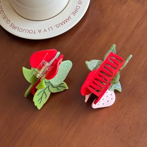 Set de pinces à cheveux fraise en acétate rouge et vert sur une assiette en céramique vintage