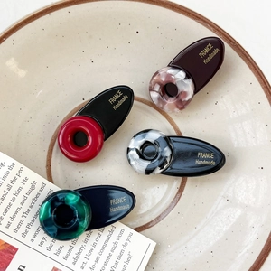 Set mit vier handgefertigten Haarklammern aus Acetat in Schildpatt-Optik auf Vintage-Teller