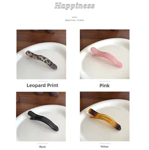 Hair clips in leopard, pink, black, and amber patterns displayed on a white plate