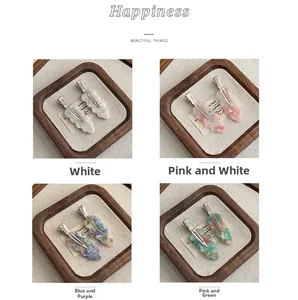 Detailed macro view of four marble texture acetate hair clips with metal duckbill base