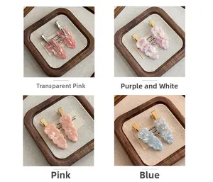 Detailed close-up of wavy acetate hair clips with marble texture and golden metal base
